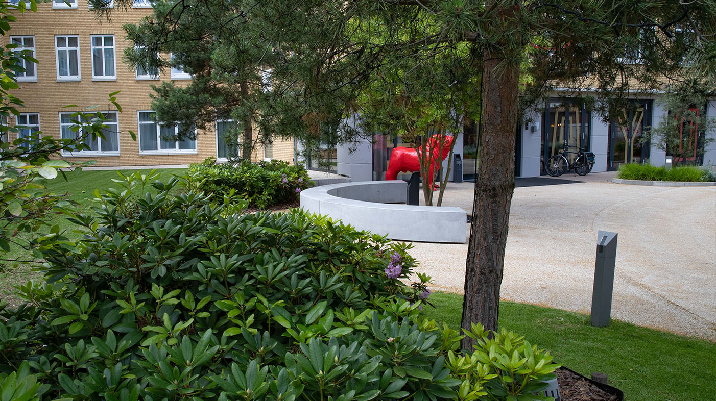 Het terras wordt omsloten door fraaie plantgroepen die karakter geven aan de omgeving.